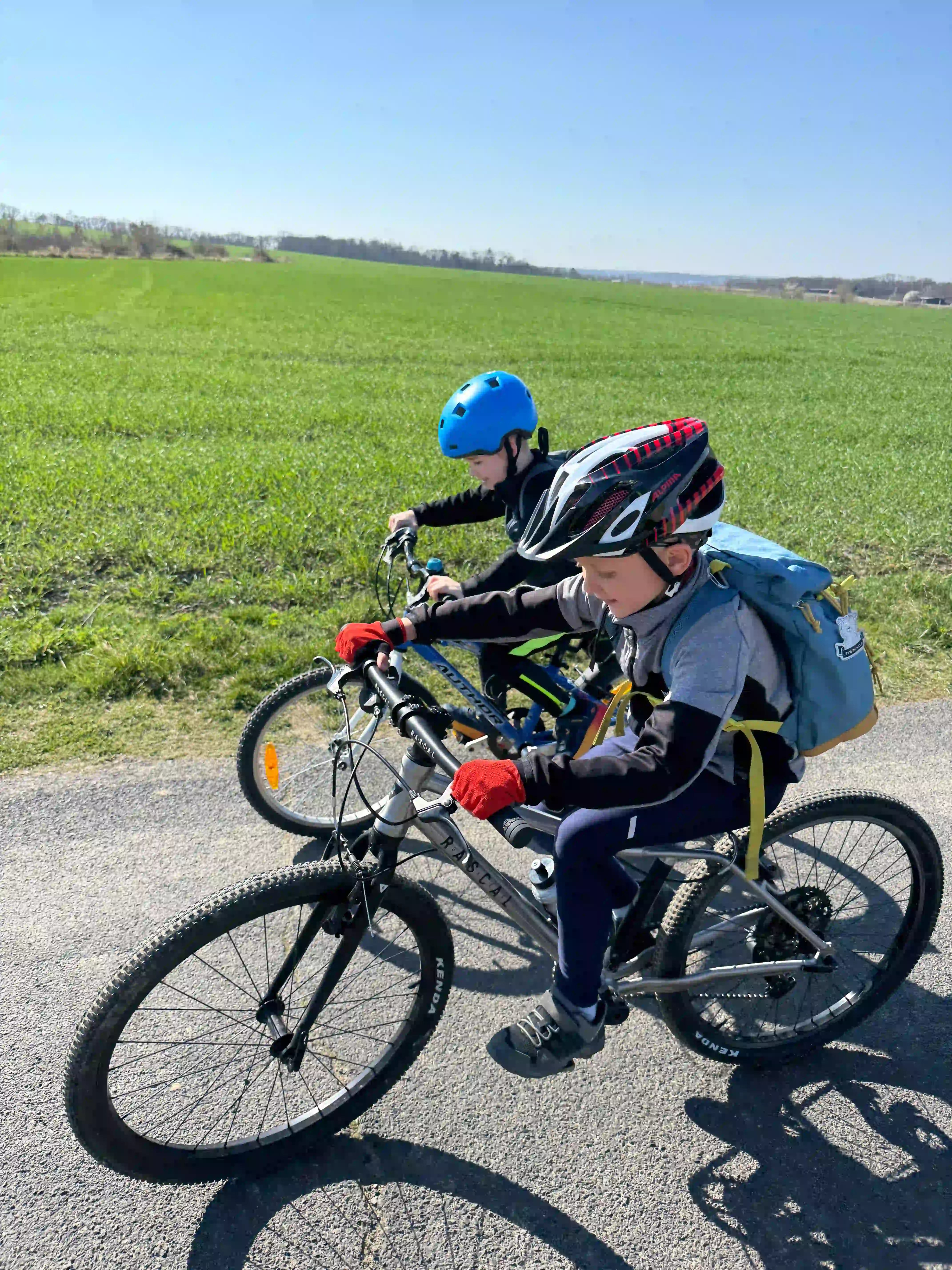 Dva malí cyklisti při jízdě na kole za hezkého počasí.
