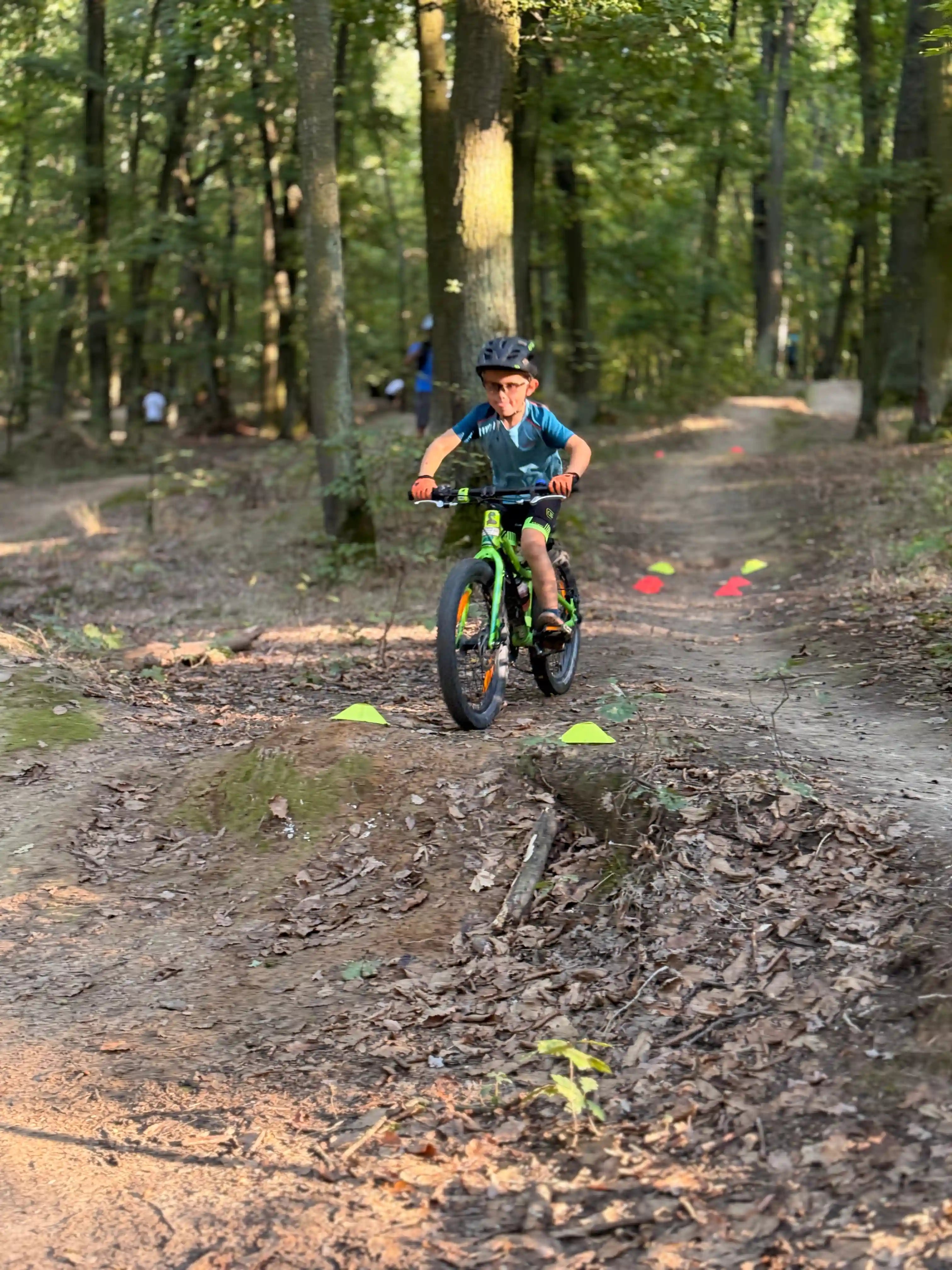 Dítě skáče drop na kole v lese.