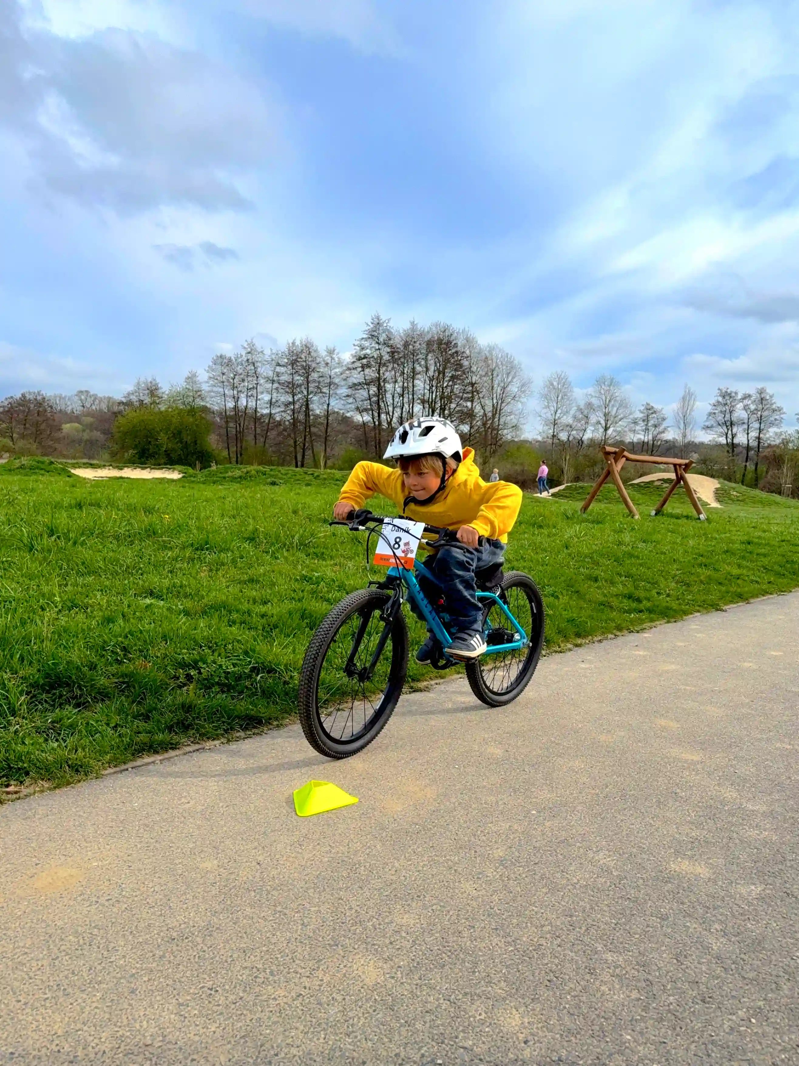 Malý cyklista s pokrčenými lokty v připravené pozici vyskočit předním kolem.