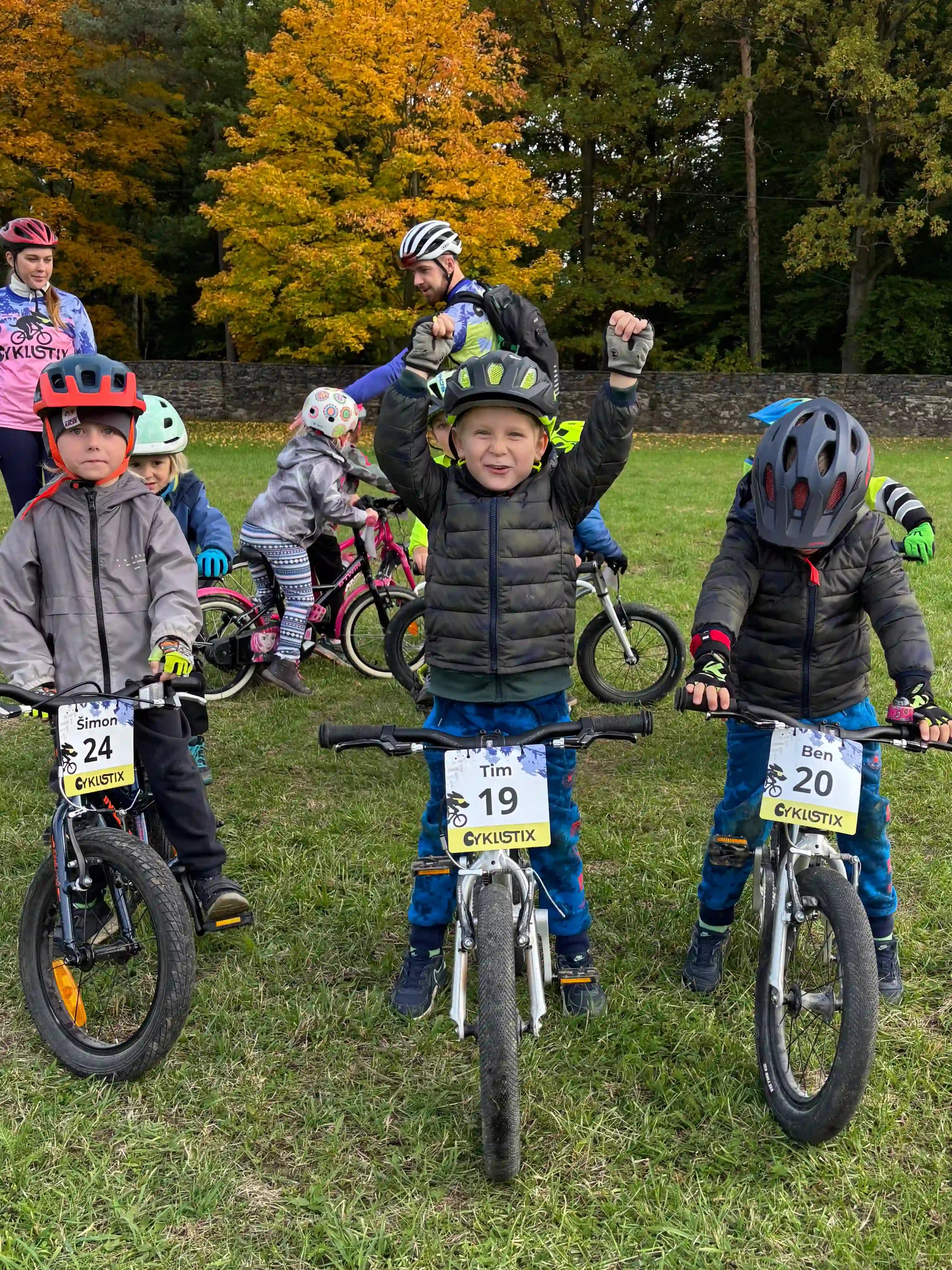 Dítě z cyklokroužku ukazuje jak slaví vítězové.
