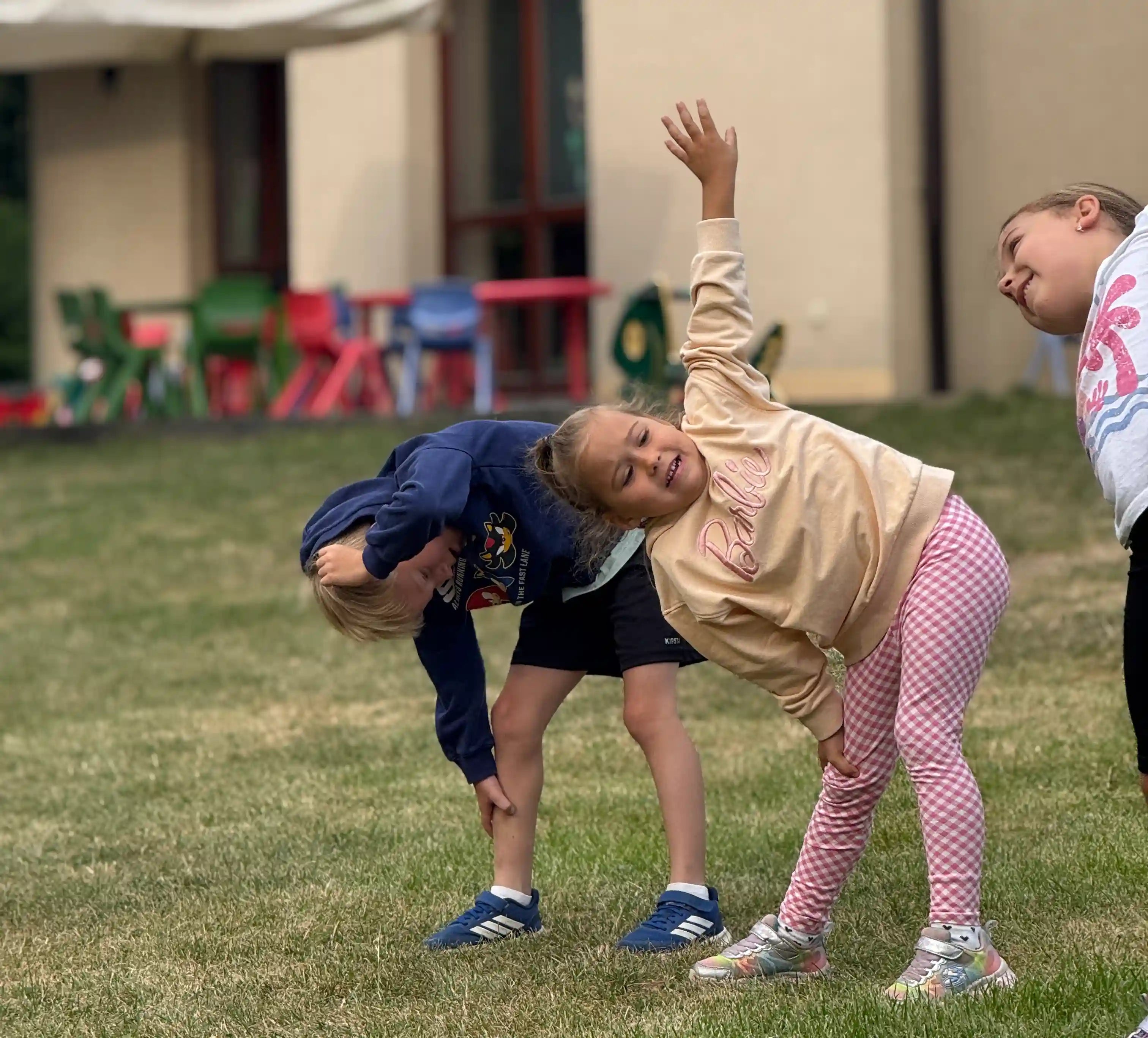 Děti si protahují záda při rozcvičce.