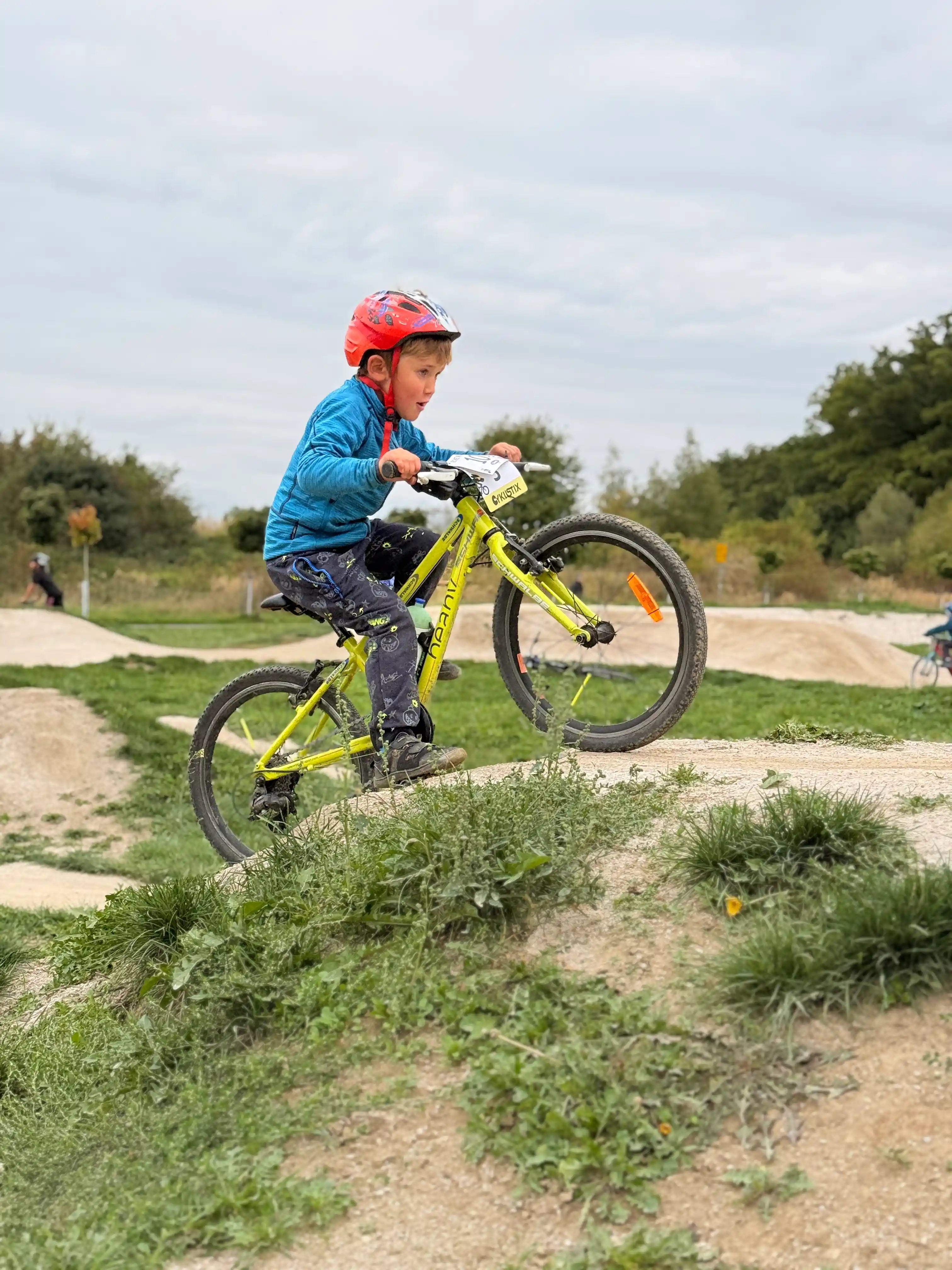 Dítě na kole jede přes velký skok.