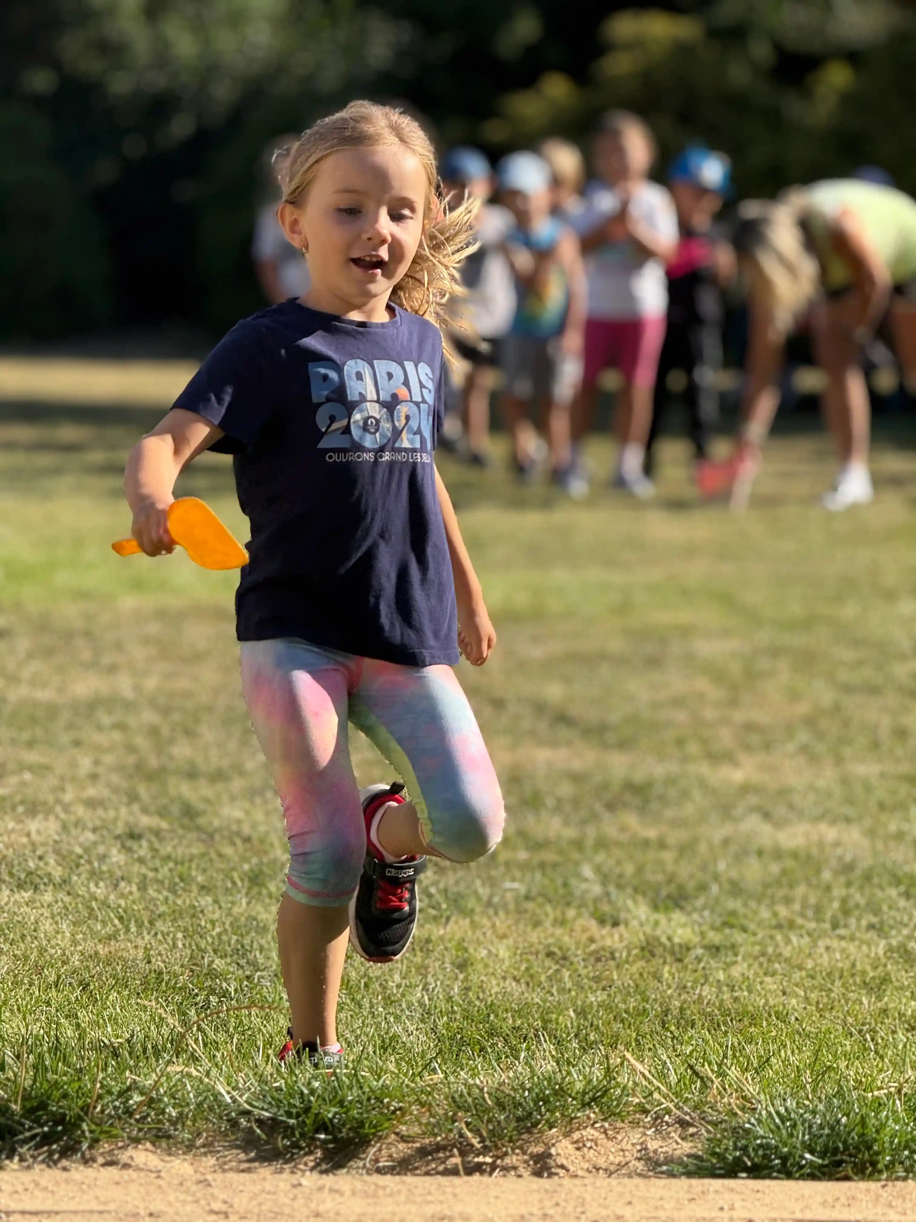 Dítě běží nabrat písek na lopatku.