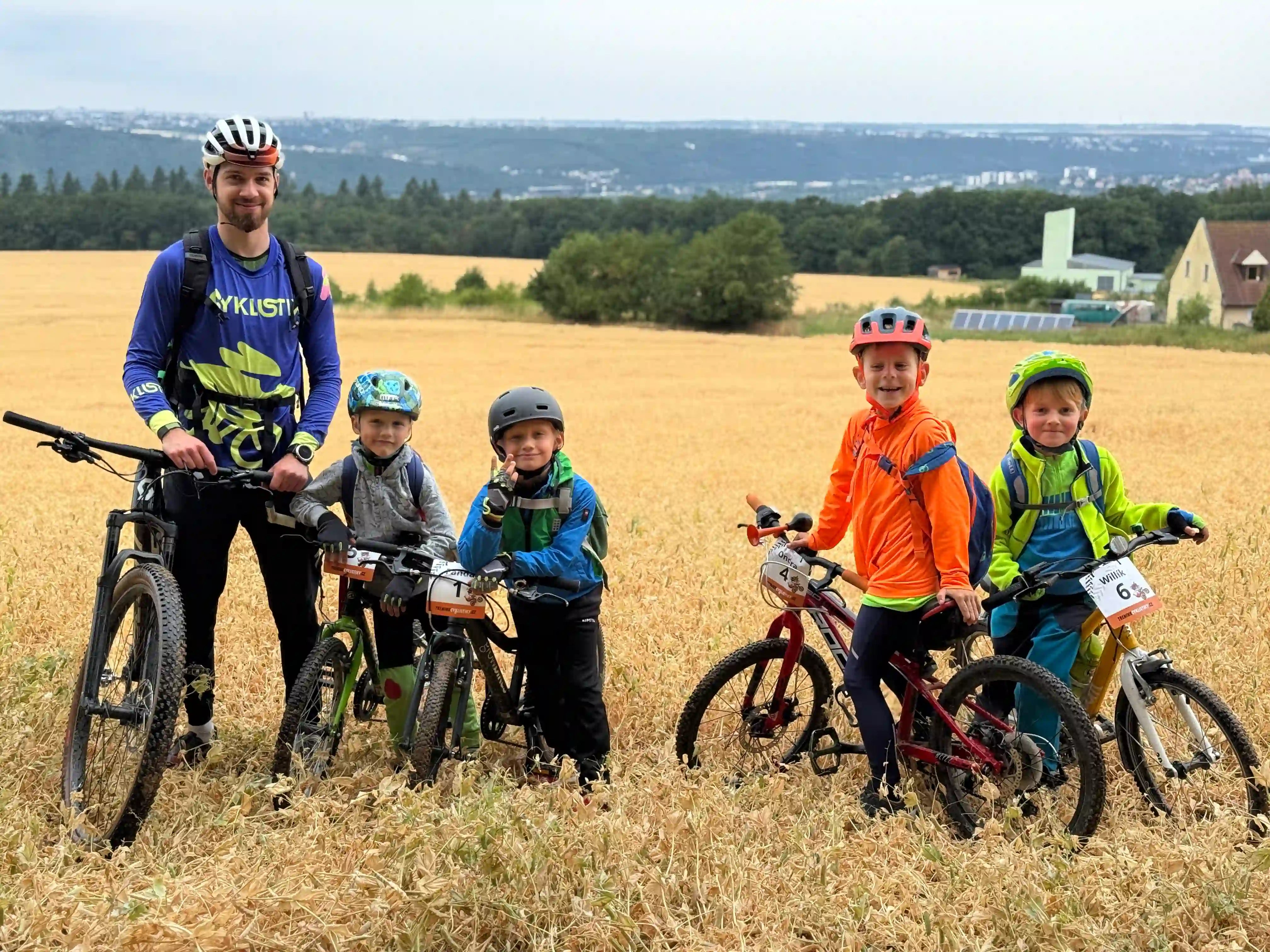Děti a trenér s koly s krásným výhledem na Prahu.